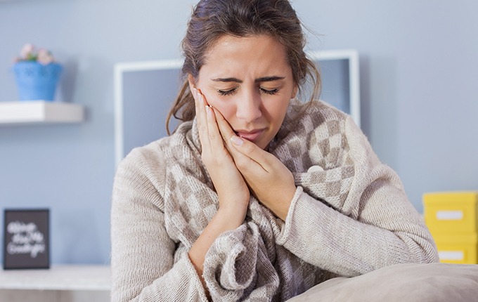 Woman with toothache holding her cheek