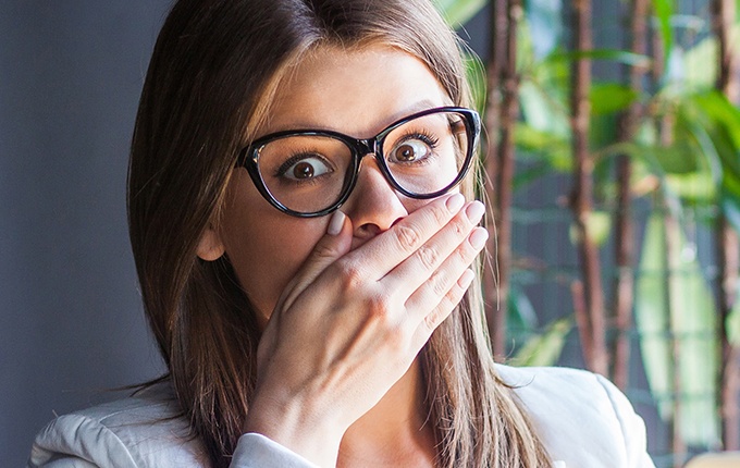 Woman with knocked out tooth covering her mouth