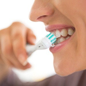 person brushing their teeth for oral hygiene