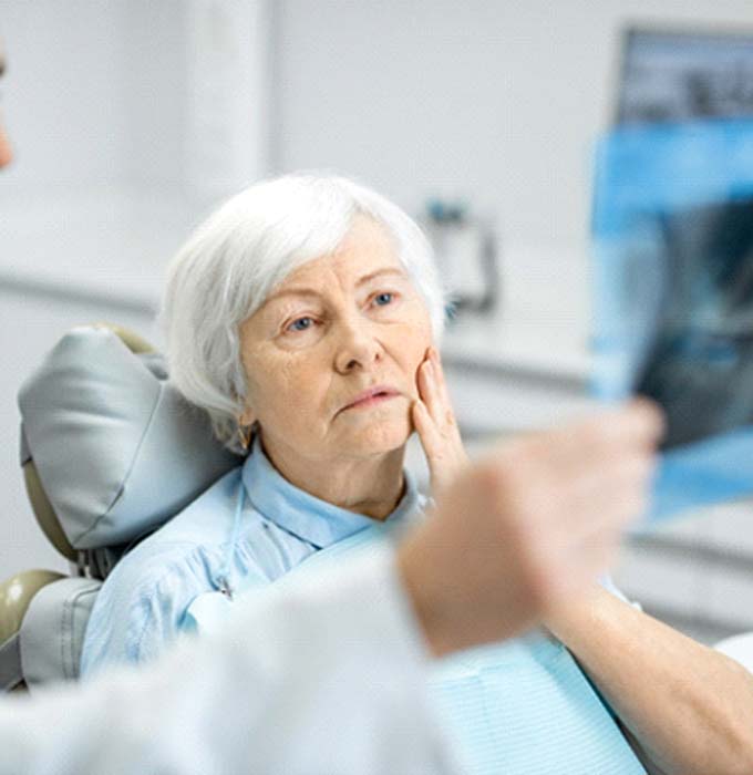Implant dentist in Muskegon showing patient an X-ray