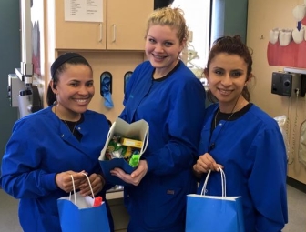 Three healthy smiles dental care of Muskegon dental team members holding gift bags