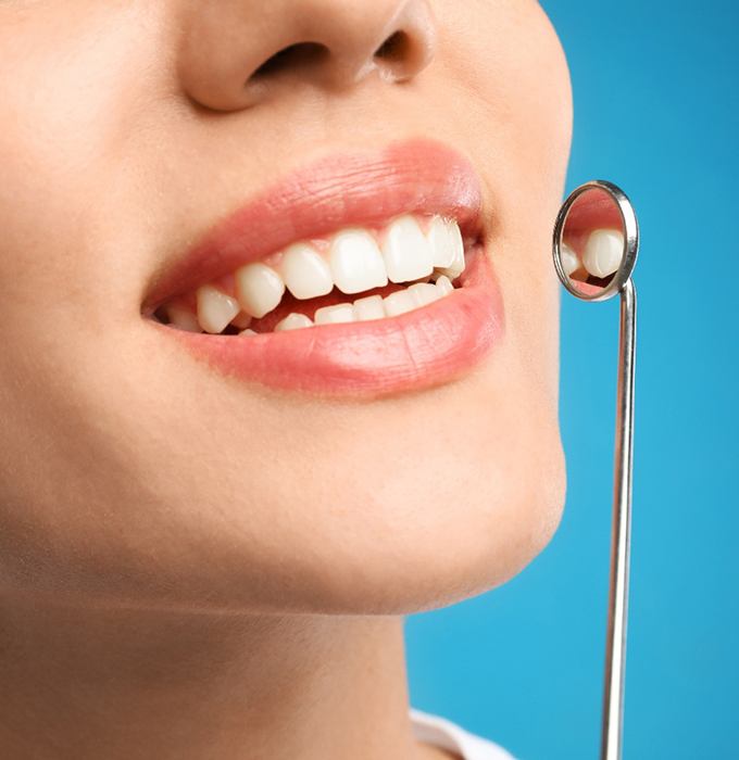 Nose-to-neck ¾ profile view of woman with perfect teeth smiling