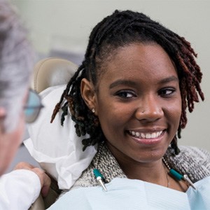 a smiling person sitting in their cosmetic dentist’s treatment chair