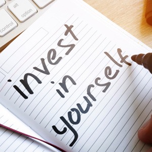 : a notepad that reads “invest in yourself