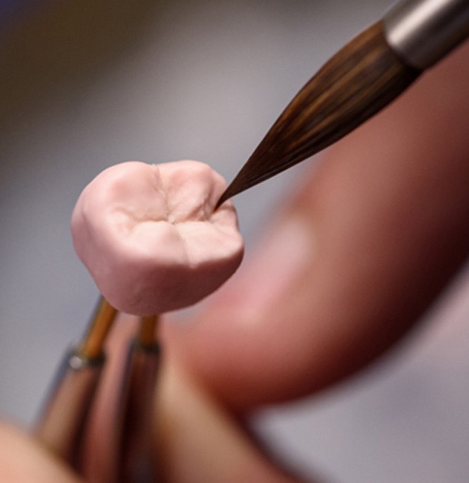 dentist sculpting dental crown 