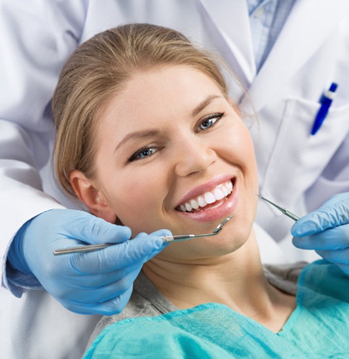 patient smiling while getting dental checkup 