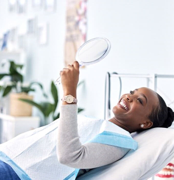 Dental Patient holding mirror and smiling