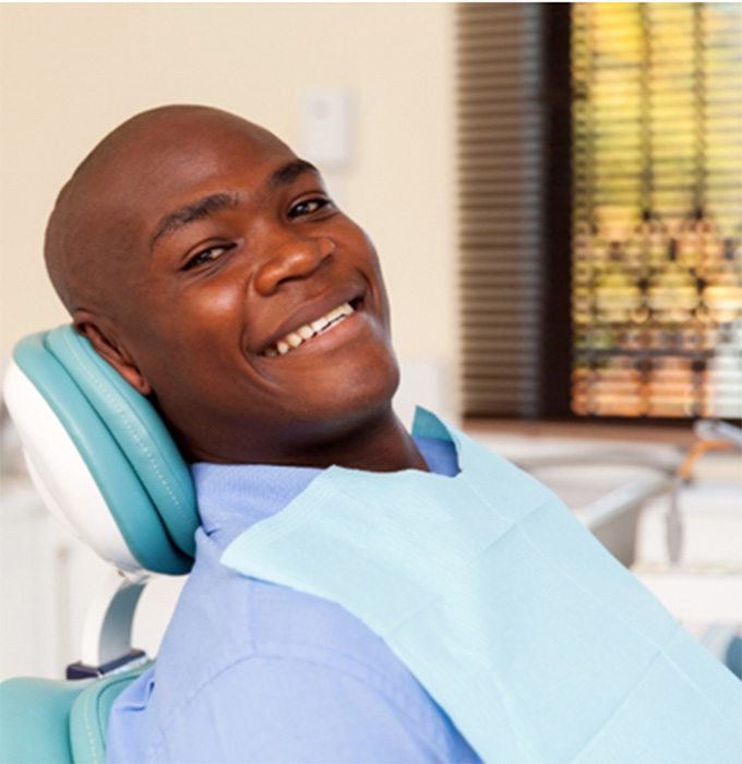 Man smiling after getting implant dentures in Muskegon 