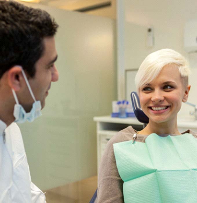 Implant dentist in Muskegon speaking with a patient