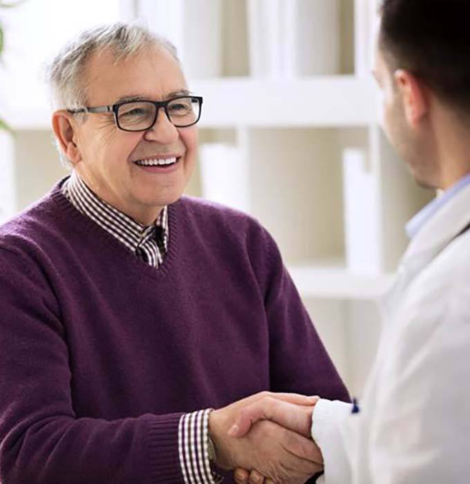 Implant dentist in Muskegon shaking hands with a patient