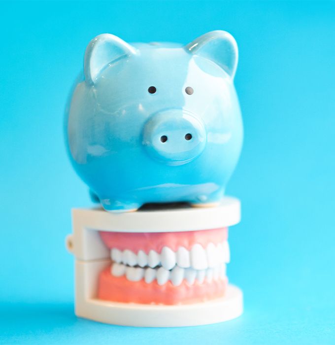 Piggy bank sitting on a set of false teeth