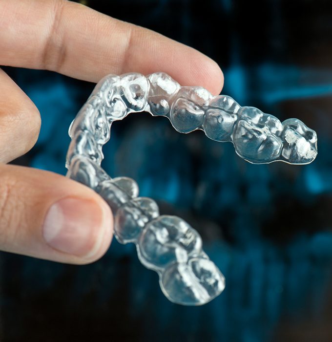 Hand holding clear nightguard for bruxism