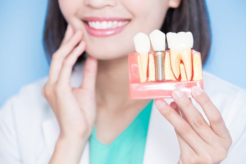 dentist holding dental implant