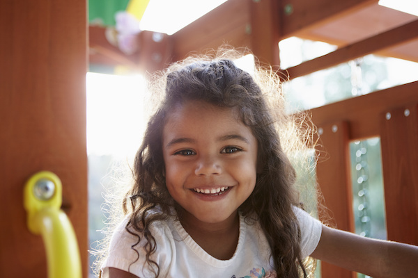 young smiling girl on play gym 