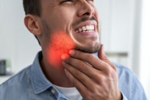 Man suffering from swelling and pain in mouth.